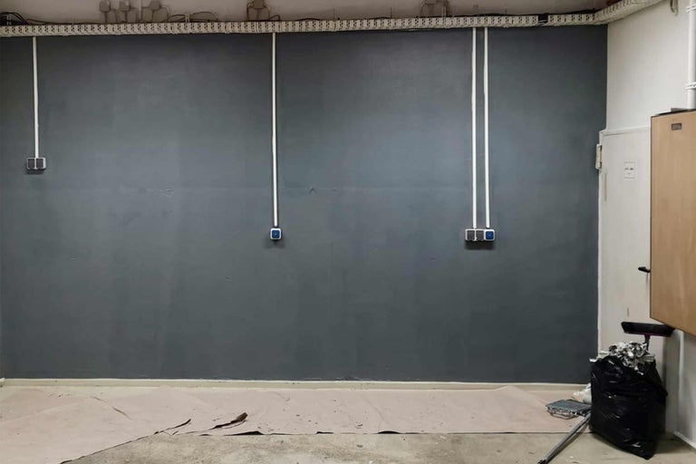 Renovierter Raum mit grauer Wand und elektrischen Leitungen