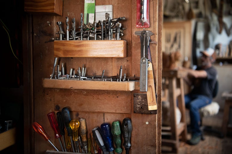 Werkzeugwand mit Bohrern, Schraubendrehern und Messwerkzeugen in einer Werkstatt
