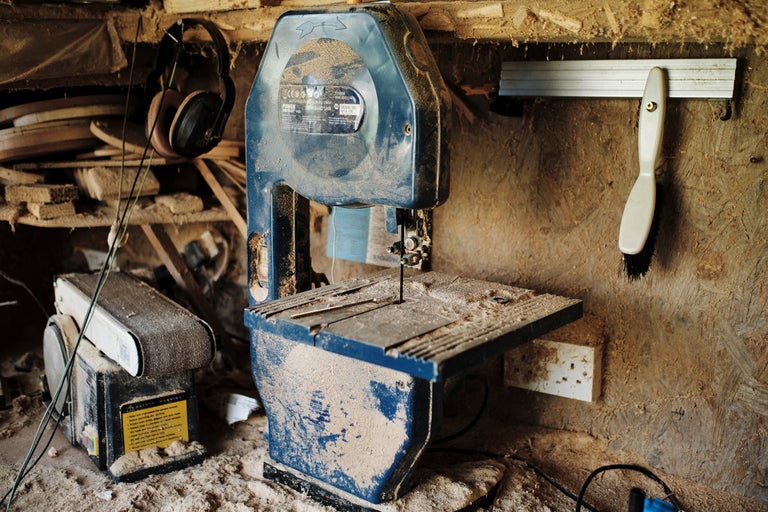Werkstatt mit Bandsäge, Schleifmaschine, Gehörschutz und Werkzeugen