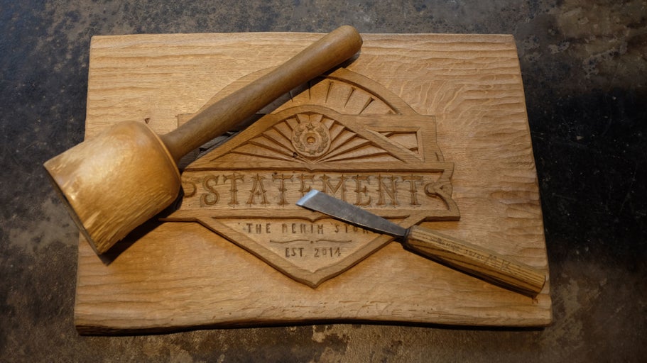 Holzbrett mit Schnitzwerkzeug und Holzhammer