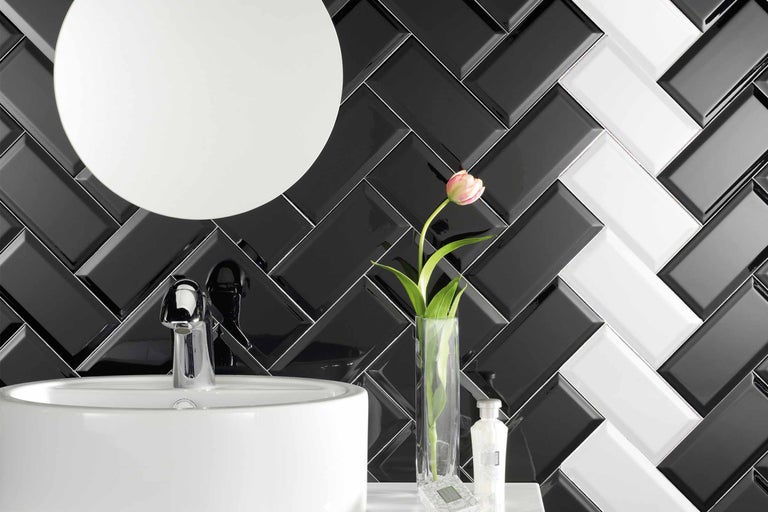 Badezimmer mit Waschbecken, Armatur, Spiegel und Fliesen in Fischgrätmuster