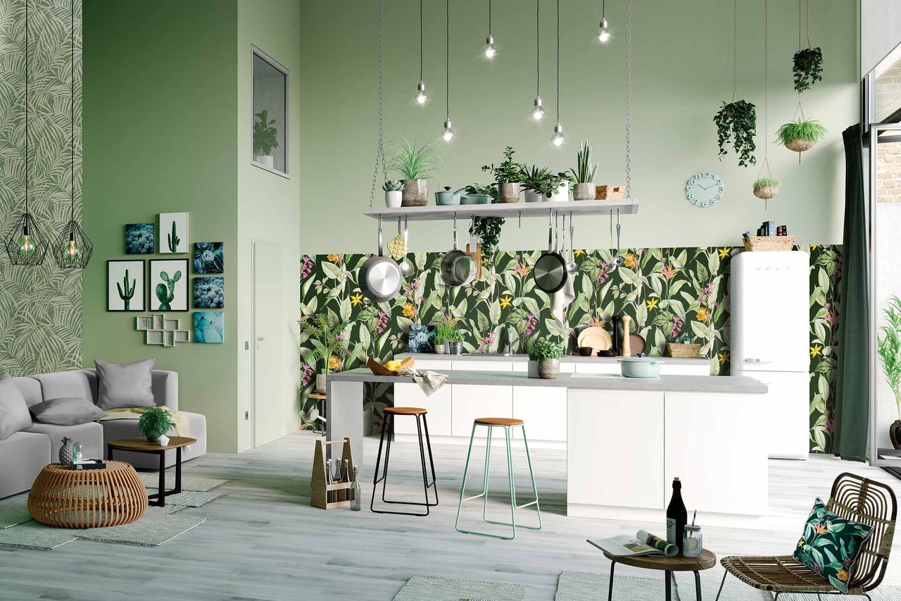 Helles Wohnzimmer mit Küchenbereich, Pflanzen, Kochutensilien und tropischer Dekoration
