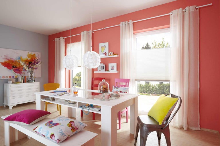 Helles Esszimmer mit Esstisch, Stühlen, Sitzbank, Vorhängen und Pendelleuchten