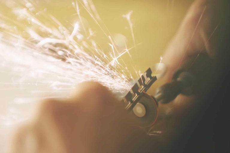 Arbeiter mit Winkelschleifer und Funkenflug