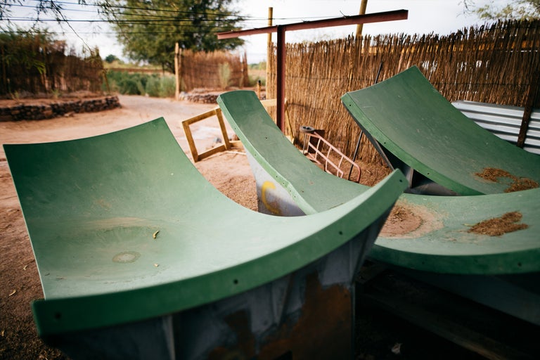 Drei grüne Halfpipes aus Beton auf einem Gelände.