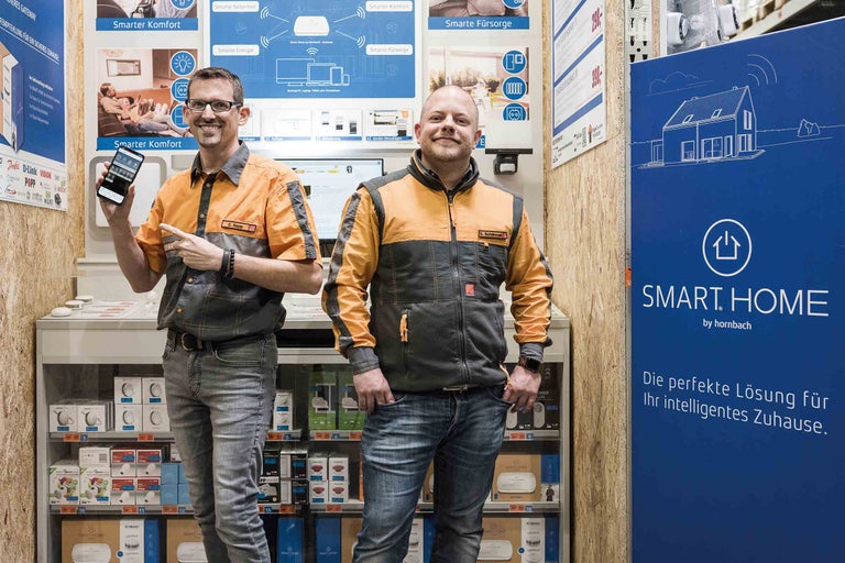 Zwei Hornbach Mitarbeiter präsentieren Smart Home Produkte.