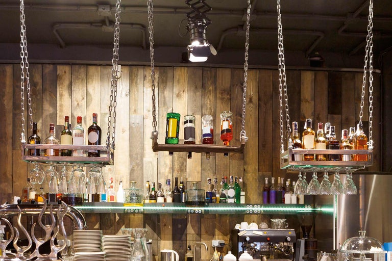 Bar mit Getränkeflaschen, Gläsern und Holzverkleidung