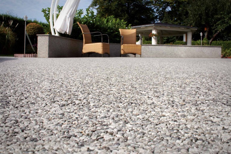 Garten mit Kiesboden, Pavillon und Korbstühlen