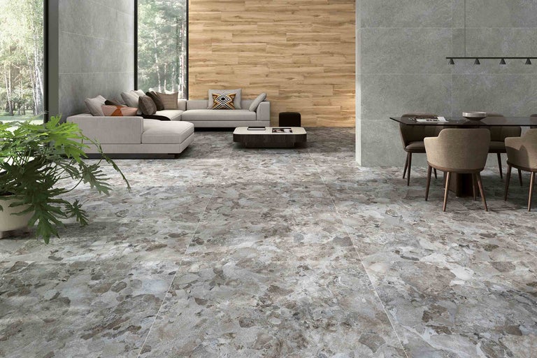 Heller Wohnraum mit Bodenfliesen in Marmoroptik, Sofa und Esstisch.