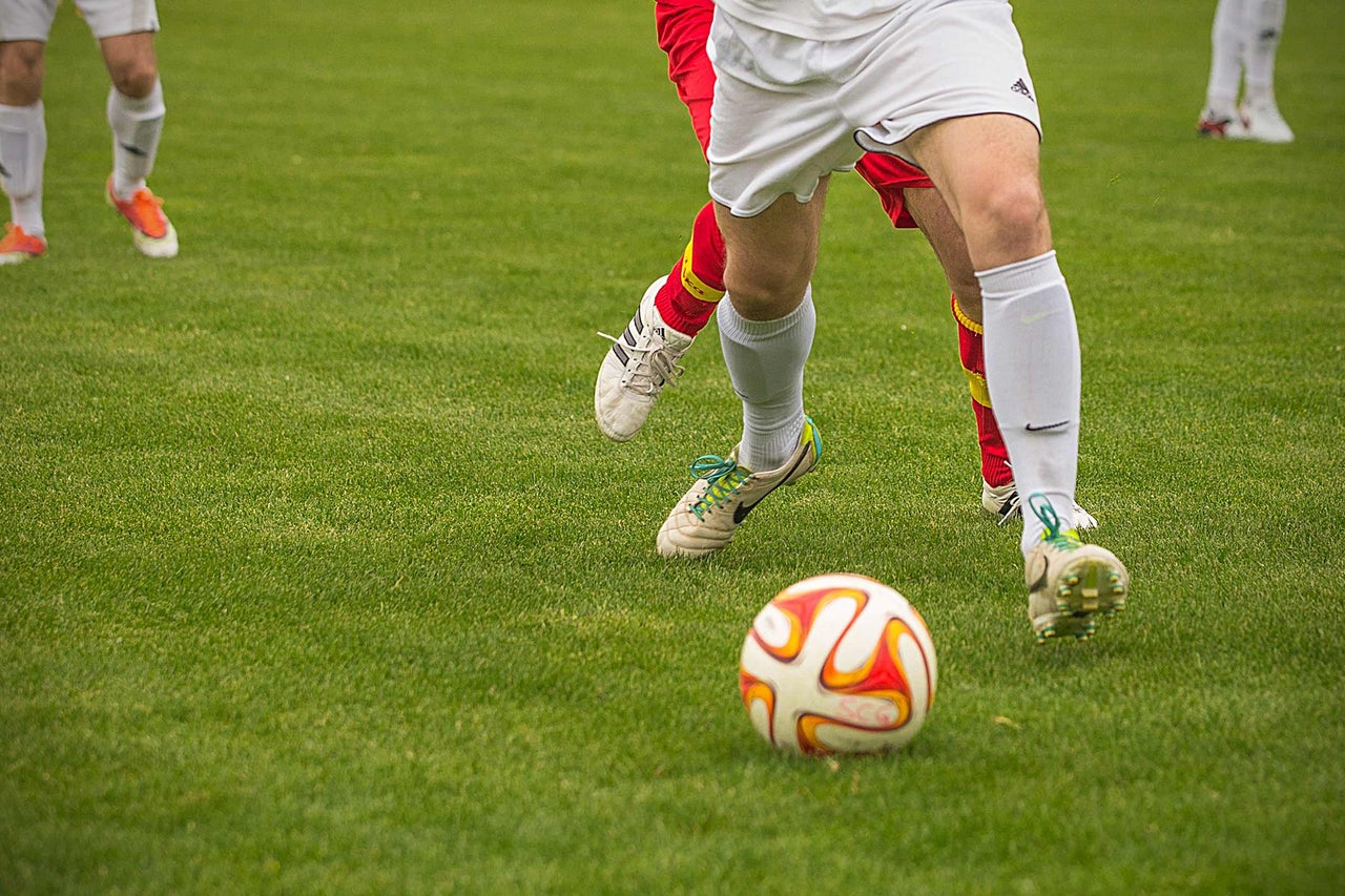 Fußballspieler auf einem grünen Rasen mit einem Fußball