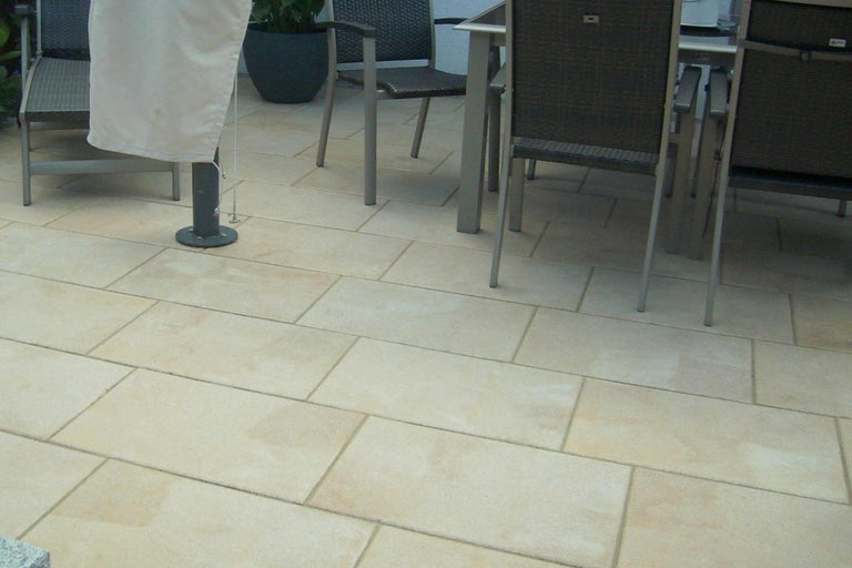 Verlegte Terrassenplatten im Außenbereich mit Gartenmöbeln