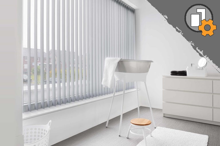 Helles Badezimmer mit Fenster, ausgestattet mit Jalousien, Badewanne, Hocker und Kommode.