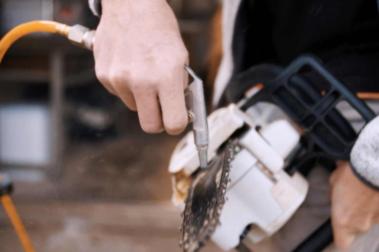 Reinigung einer Kettensäge mit einer Ausblaspistole