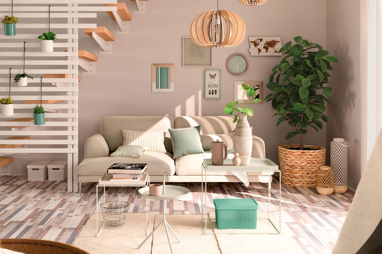 Helles Wohnzimmer mit Sofa, Beistelltischen, Zimmerpflanzen und dekorativen Elementen