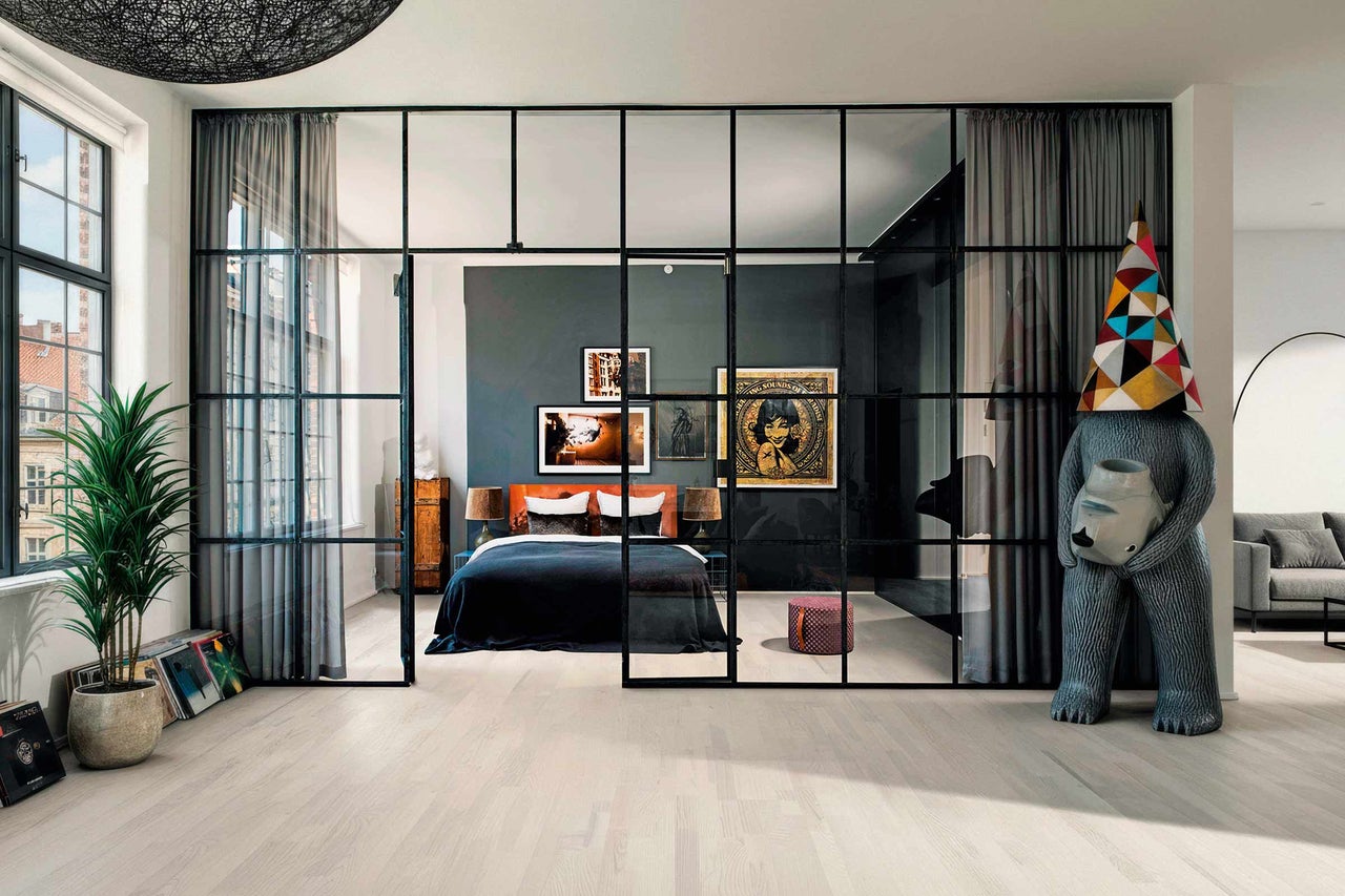 Schlafzimmer mit Bett, Kunst und Raumteiler im modernen Design