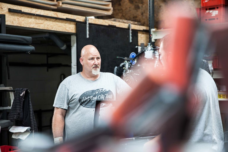 Werkstattszenenbild mit Männern bei der Arbeit an einem Motor.