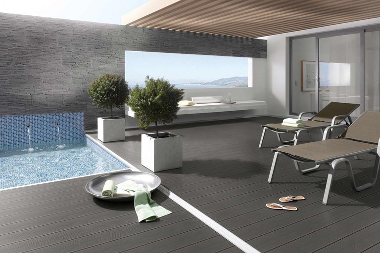 Terrasse mit Pool, Liegestühlen und Pflanzenkübeln für eine entspannende Atmosphäre