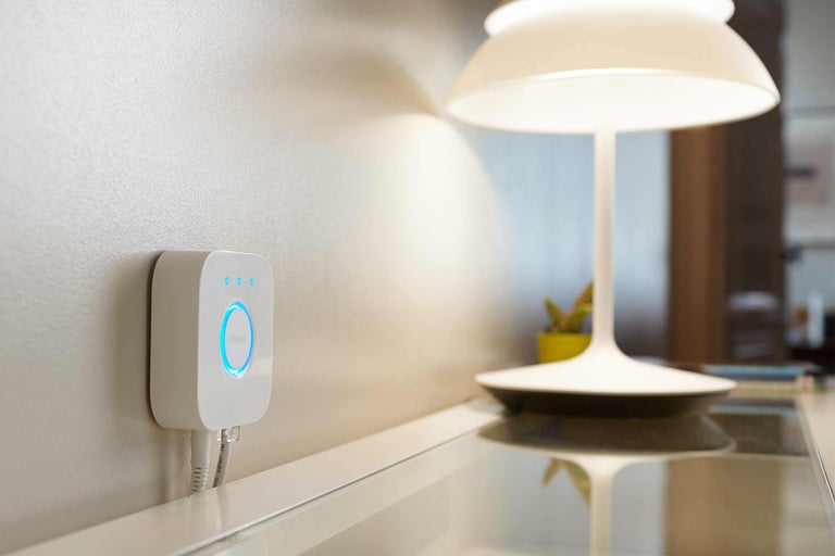 Philips Hue Bridge mit Tischleuchte auf Tisch
