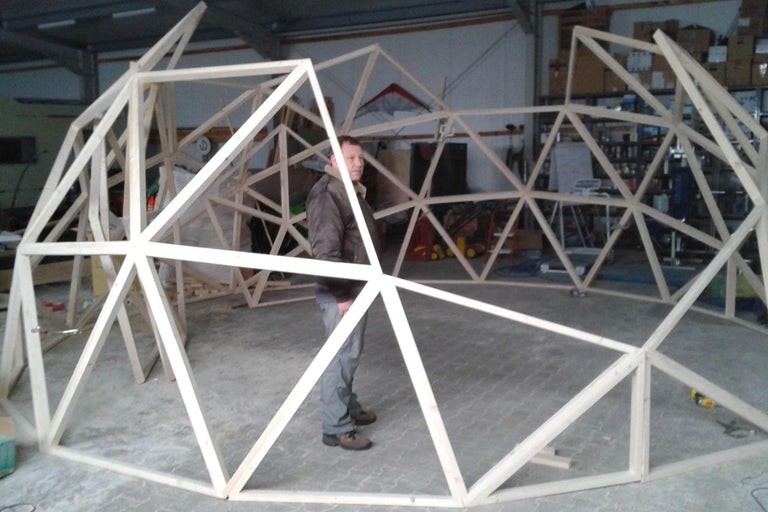 Geodätischer Kuppelbausatz aus Holz mit Mann zum Größenvergleich