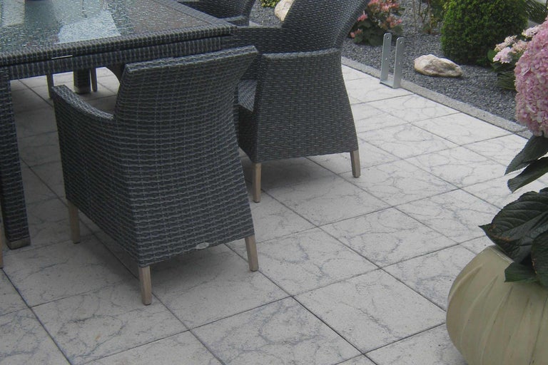 Gartensitzgruppe mit Tisch und Stühlen auf Steinfliesen