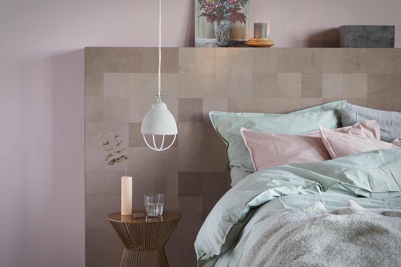 Schlafzimmer mit Bett, Nachttisch und Pendelleuchte für stimmungsvolle Beleuchtung