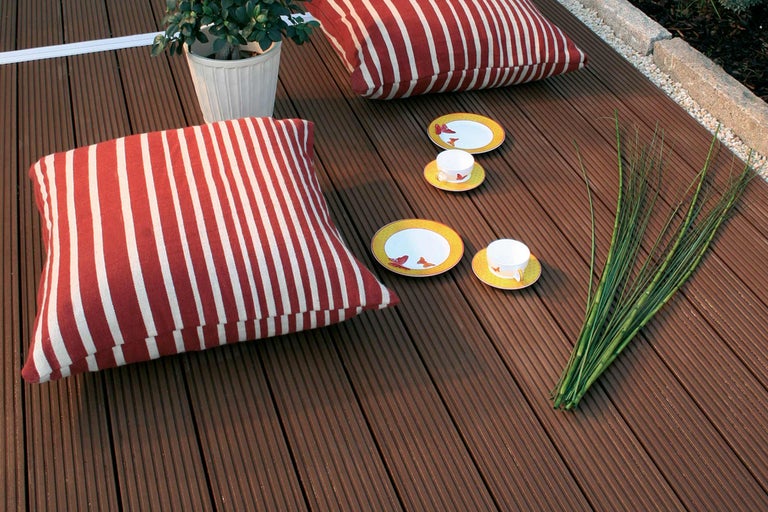 Terrassendielen mit Kissen, Geschirr und Pflanze