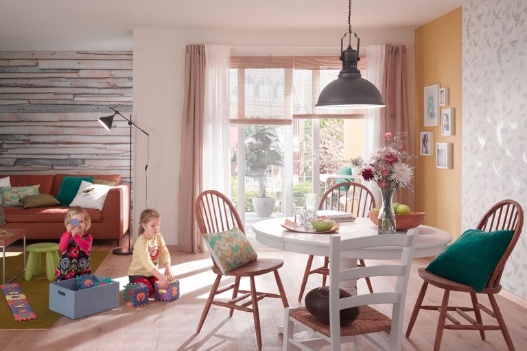 Heller Essbereich mit Esstisch, Stühlen und spielenden Kindern