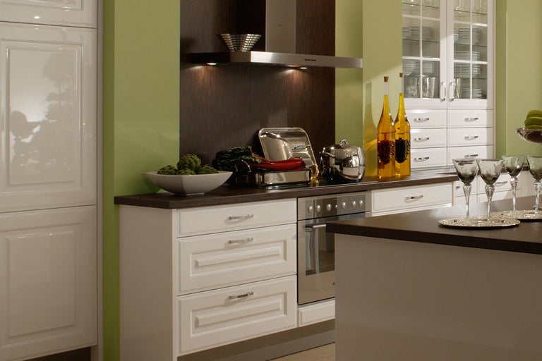 Küchenszene mit Küchenschränken, Kochfeld und Dunstabzugshaube