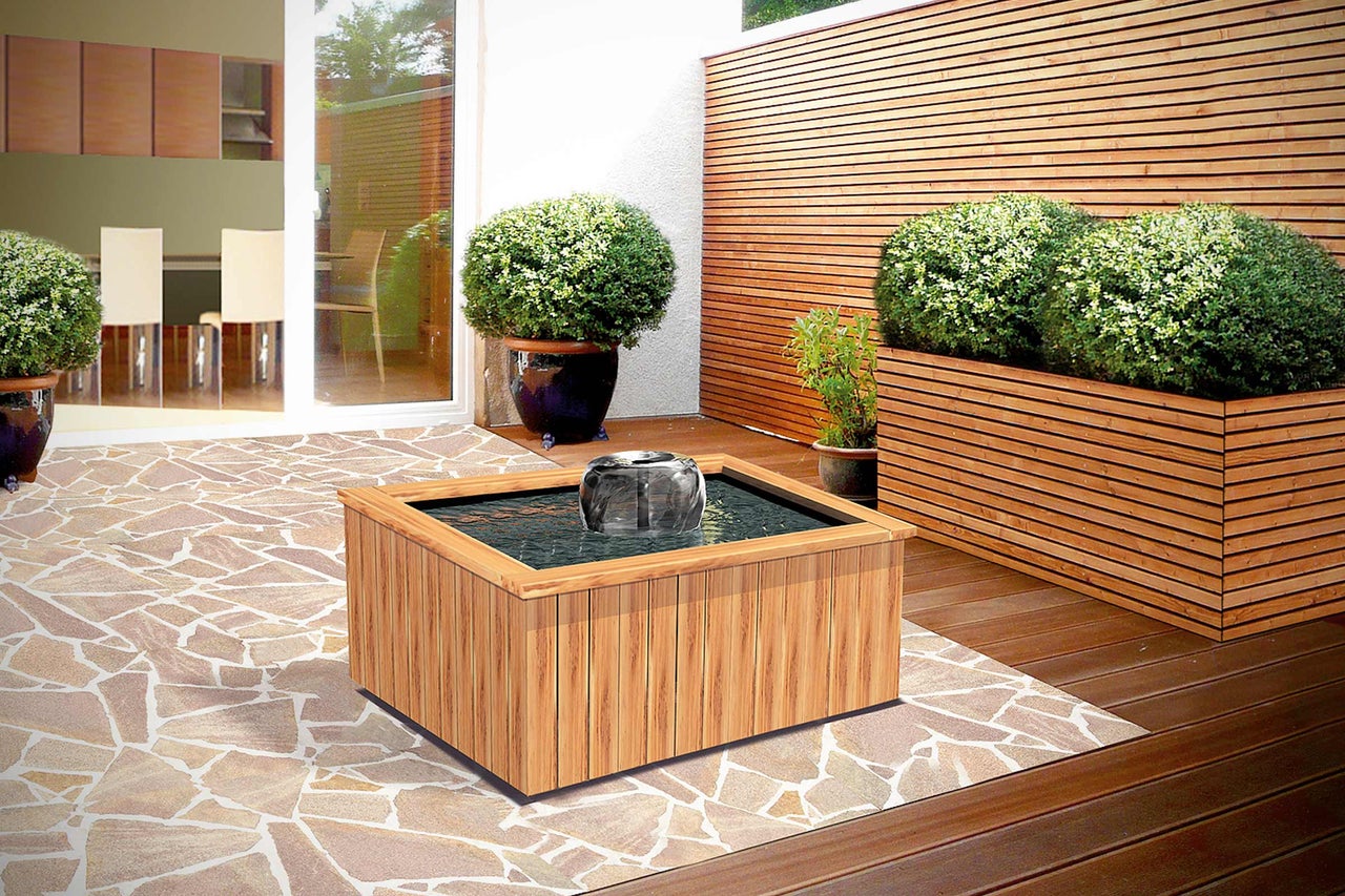 Garten mit Wasserspiel, Pflanzen und Holzelementen