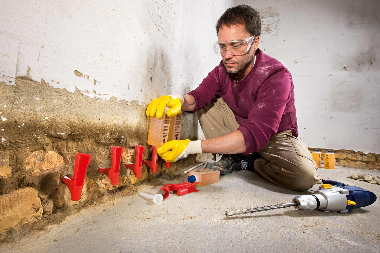 Handwerker bei der Injektion einer Horizontalsperre in eine Wand zur Sanierung von Feuchtigkeitsschäden