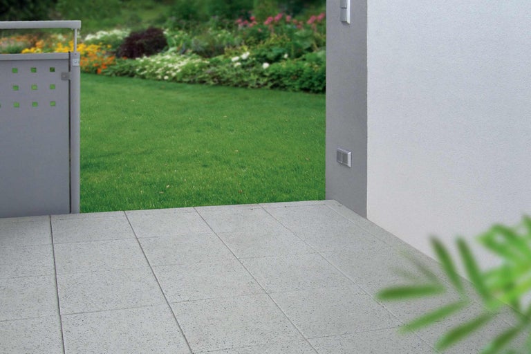 Außenbereich mit Terrassenplatten und Gartenzaun