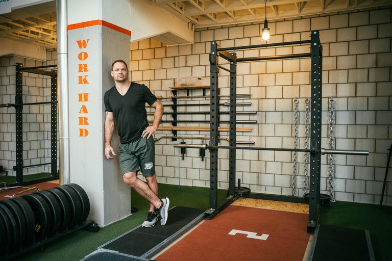 Fitnessstudio mit Gewichtheberaum und Mann an einer Wand