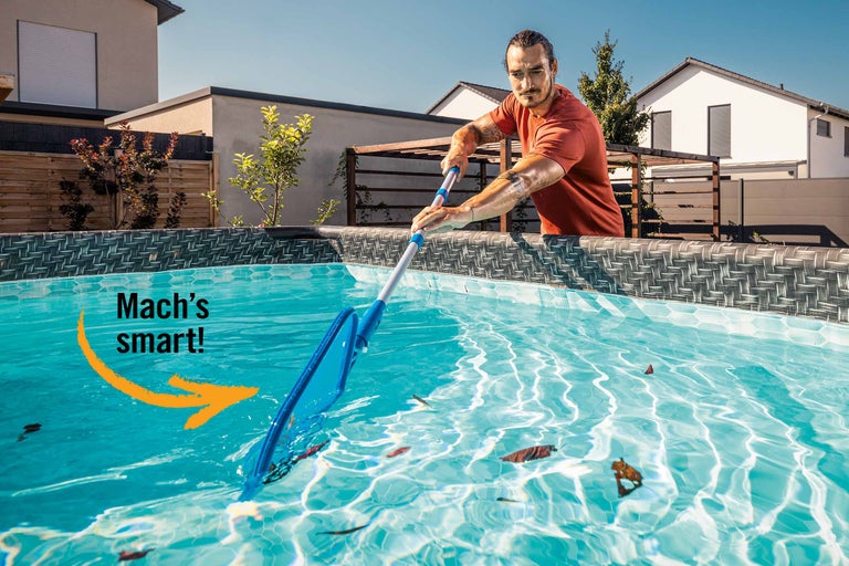 Mann reinigt Pool mit Kescher von Blättern