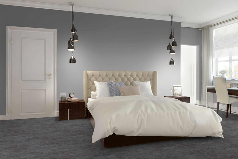 Schlafzimmer mit Bett, Nachttischen, Tür und Pendelleuchten