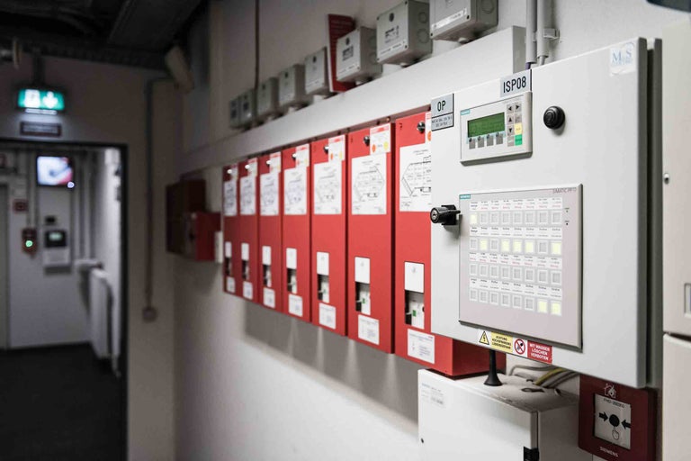 Brandmeldeanlage mit Bedienfeld und Warnhinweisen an der Wand