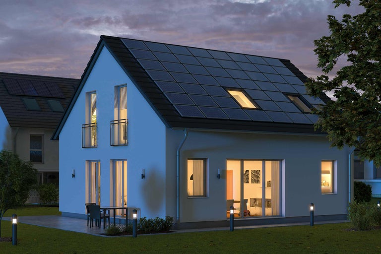Haus mit Solaranlage auf dem Dach bei Dämmerung