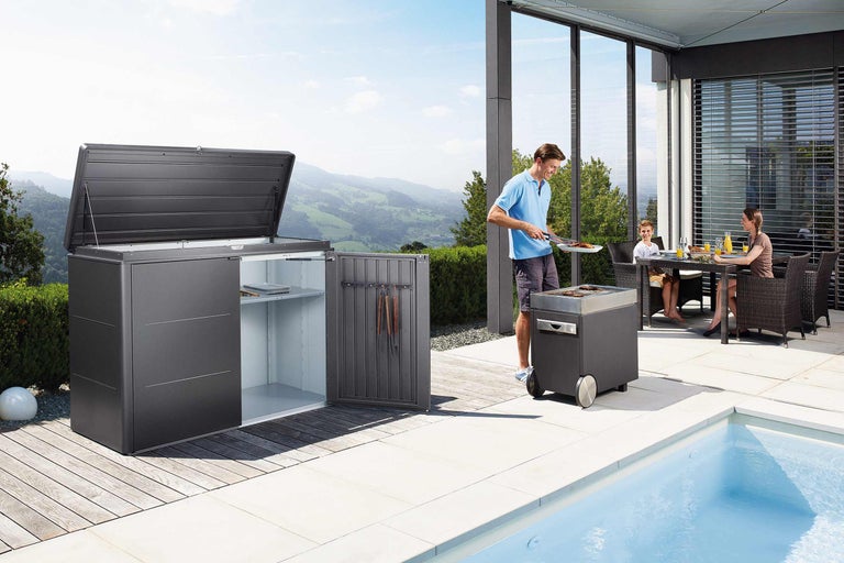 Terrasse mit Gerätebox, Grill und Familie beim Essen im Freien