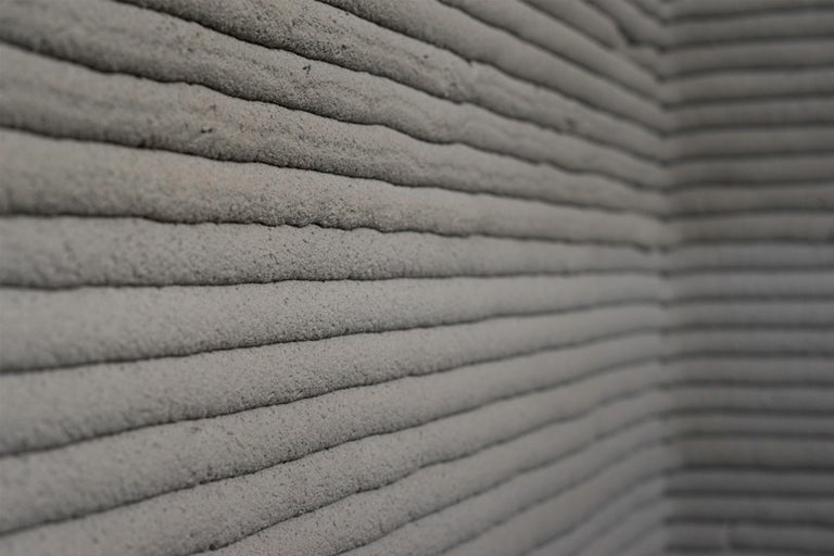 Nahaufnahme einer Wand mit horizontalen Zementlinien, hergestellt im 3D-Druckverfahren.
