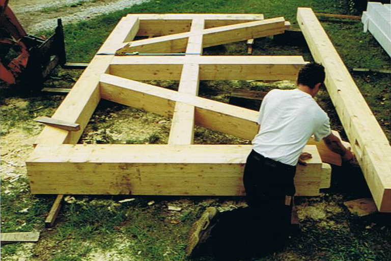 Holzrahmenkonstruktion mit einer Person beim Bau auf dem Boden