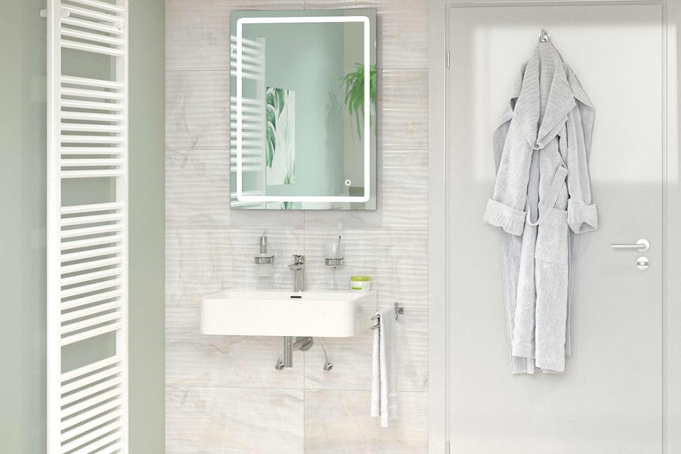 Helles Badezimmer mit Waschbecken, beleuchtetem Spiegel, Heizkörper und Bademantel an der Tür