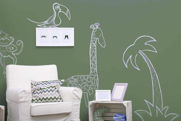 Dekoratives Interieur mit Kreidezeichnungen von Tieren an der Wand, einem Sessel und Dekorationsgegenständen.