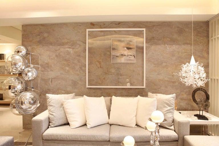 Helles Wohnzimmer mit Sofa, Kissen, Bild, Lampe und Dekorationsgegenständen