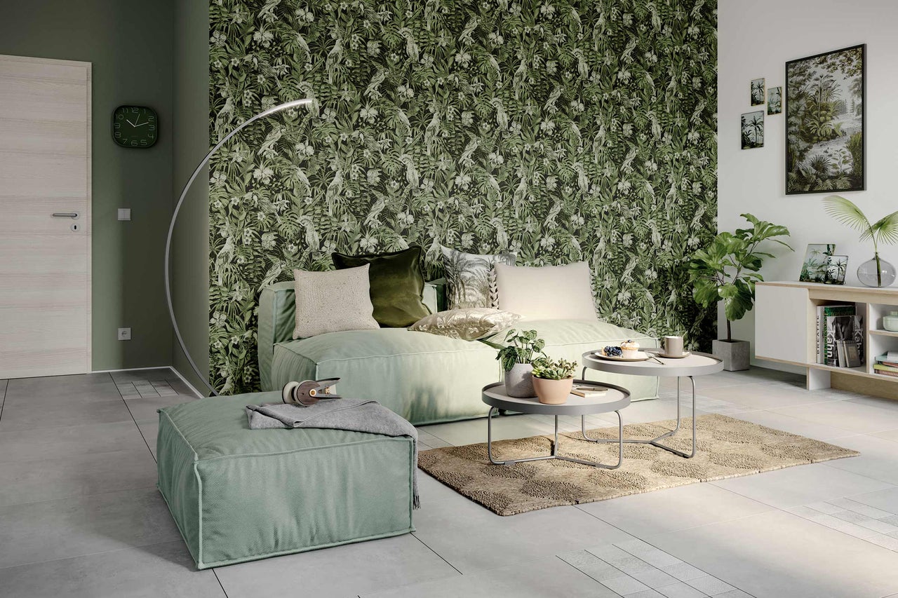 Wohnzimmer mit grüner Dschungeltapete, Sofa, Pouf, Teppich und Beistelltischen