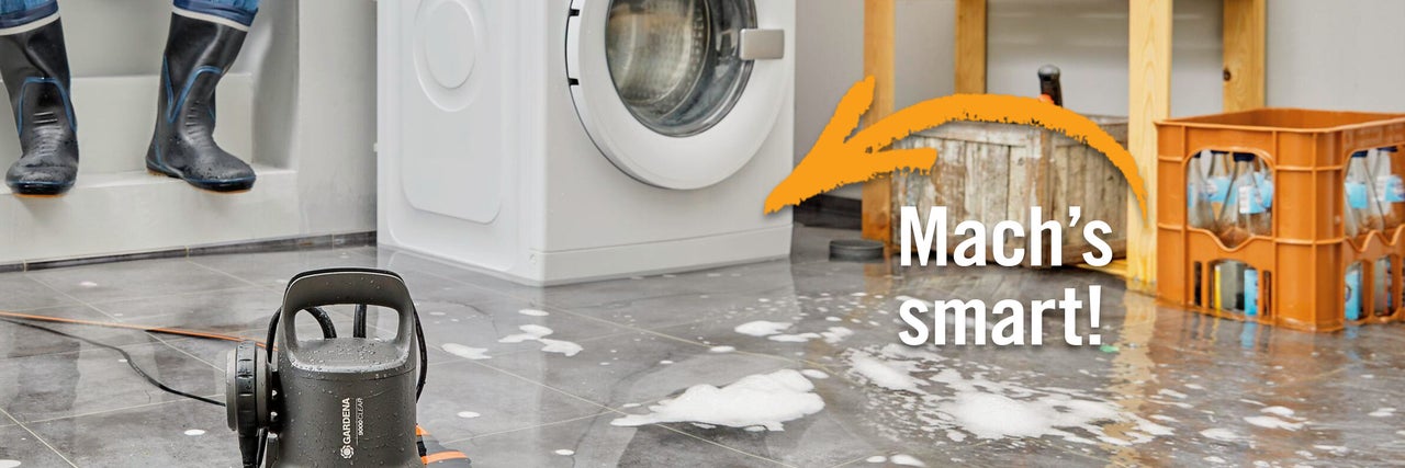 Szene mit Gardena Klarwasser-Tauchpumpe, Waschmaschine, Gummistiefeln und Wasserkisten auf gefliestem Boden mit Wasser