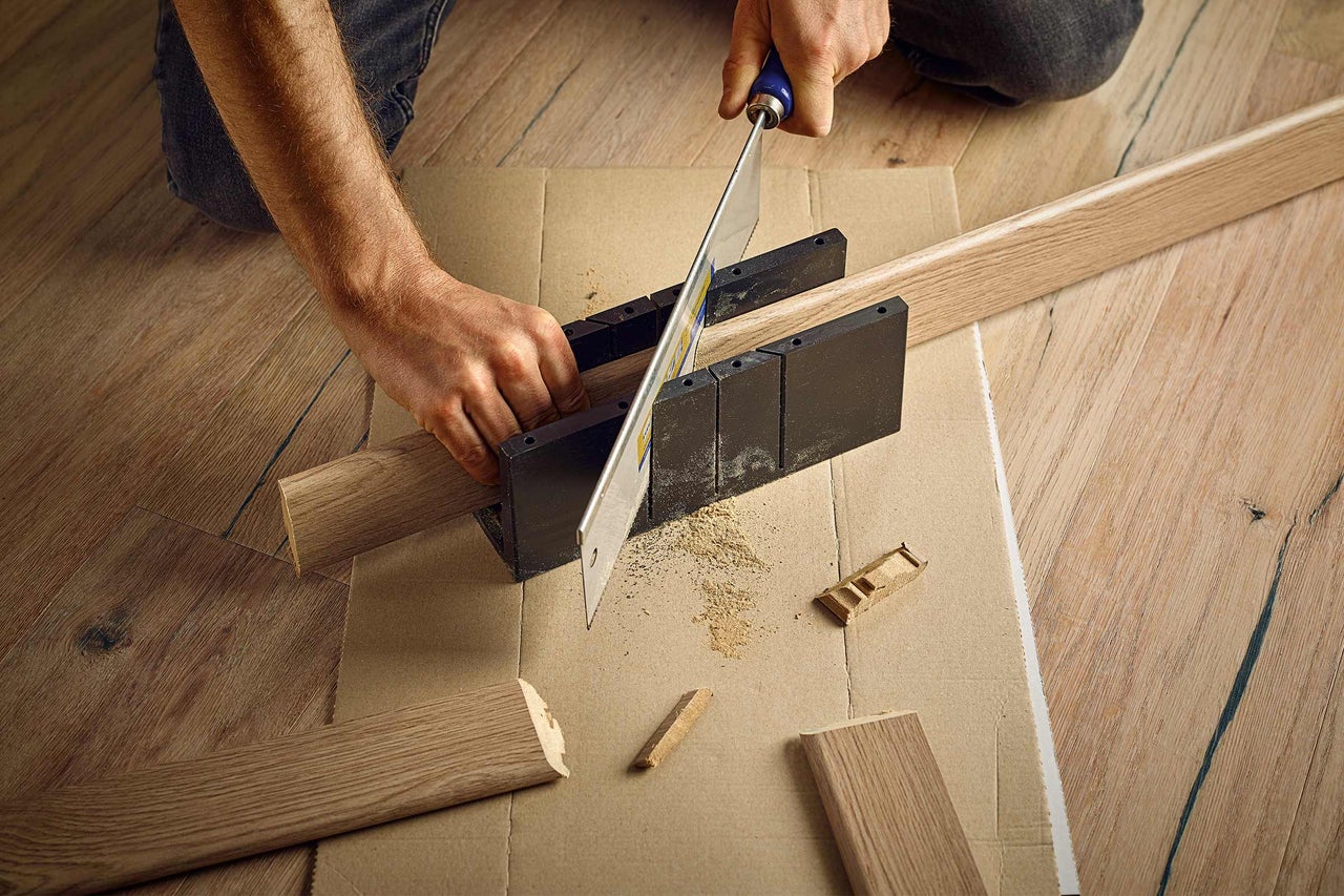 Zuschnitt von Holzleisten mit einer Säge und Schneidlade