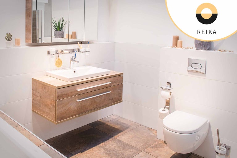 Helles Badezimmer mit Waschtischunterschrank aus Holz, Toilette und Spiegel