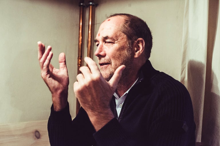 Mann mit Verletzungen am Kopf gestikuliert mit den Händen