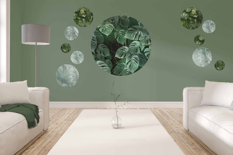 Wohnzimmer mit Sofas, Stehlampe und Wanddekoration mit Pflanzenmotiven