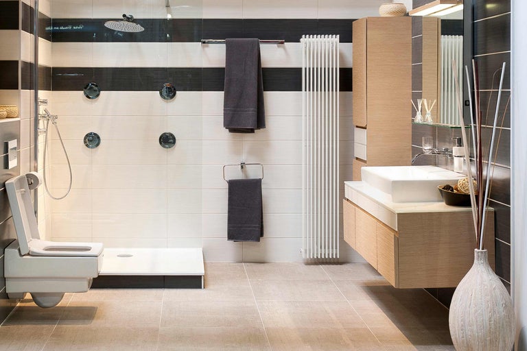 Modernes Badezimmer mit Toilette, Dusche, Heizkörper und Waschtisch