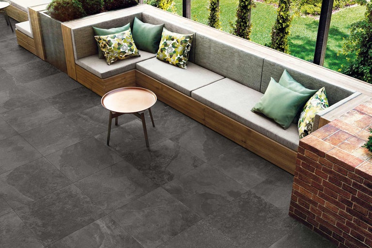 Außenbereich mit Fliesenboden, Sitzgelegenheiten und Tisch